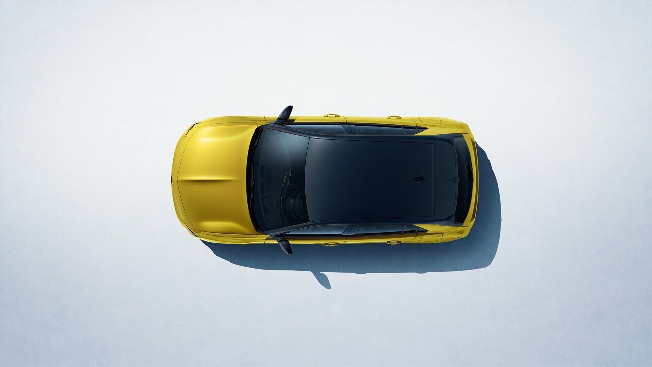 Vista superior de um Opel Astra Hatchback amarelo com tejadilho preto